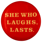 A red pinback button with yellow text reading: She who laughs, lasts.